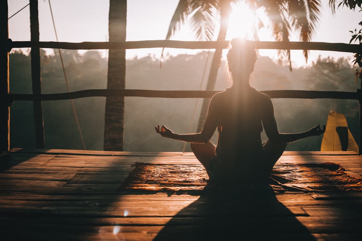 Persona en meditación sobre una terraza al amanecer